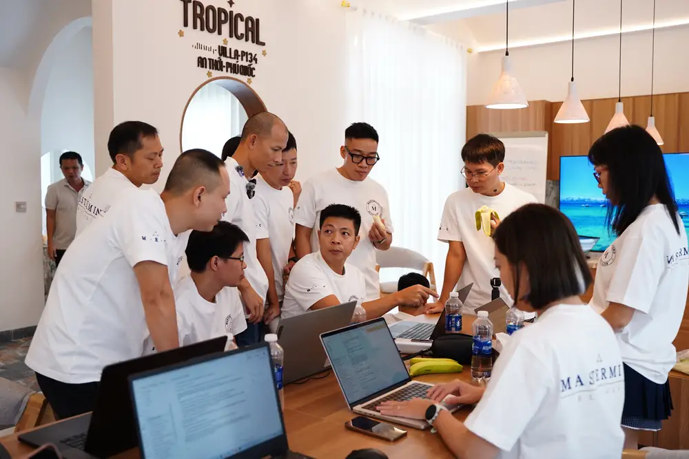 Cả lớp đứng quây quanh một chiếc laptop trong phòng học tại villa Phú Quốc
