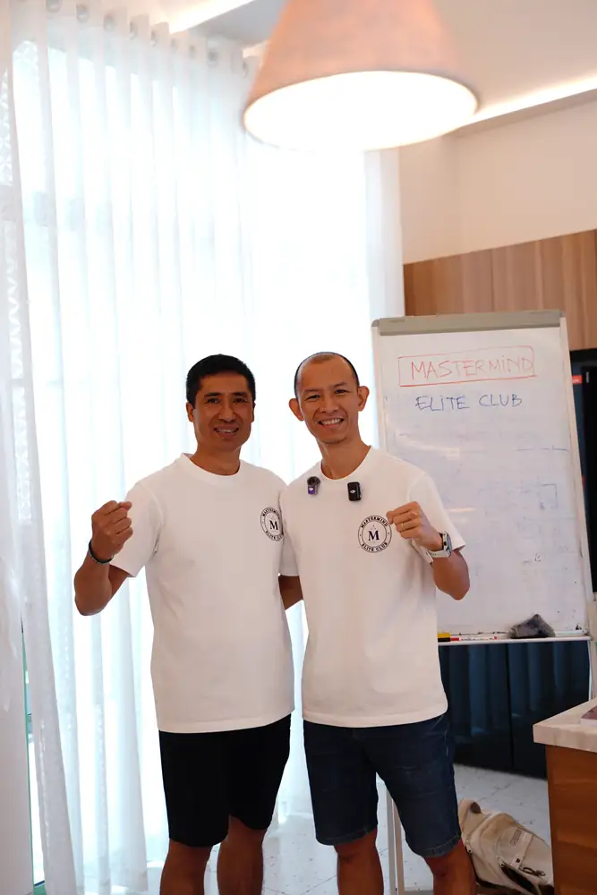 Hai học viên chụp ảnh kỷ niệm trước bảng Mastermind Elite Club