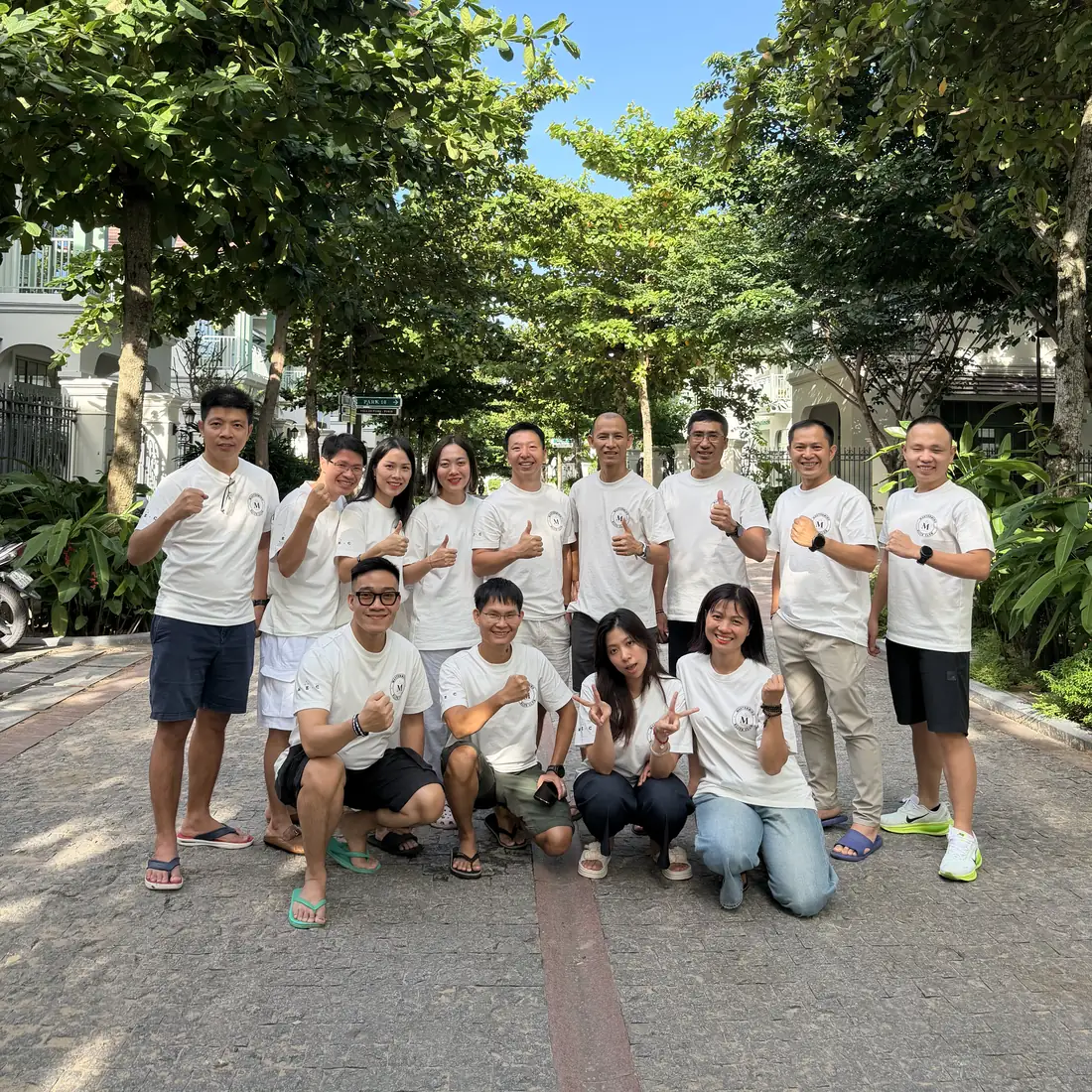 Toàn bộ thành viên Mastermind Elite Club chụp chung dưới hàng cây tại Phú Quốc, tất cả mặc áo trắng đồng phục MEC